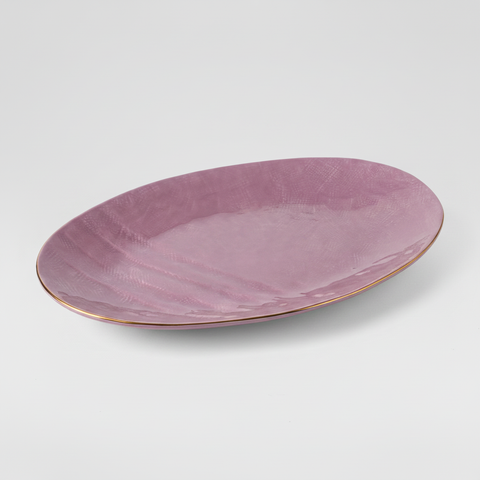 Vassoio ovale malva con bordo dorato su sfondo grigio