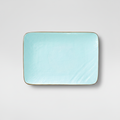 Piatto turchese rettangolare su sfondo grigio con ombra