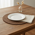 Sottopiatto rotondo spirale naturale e marrone ambientato su tavola in legno