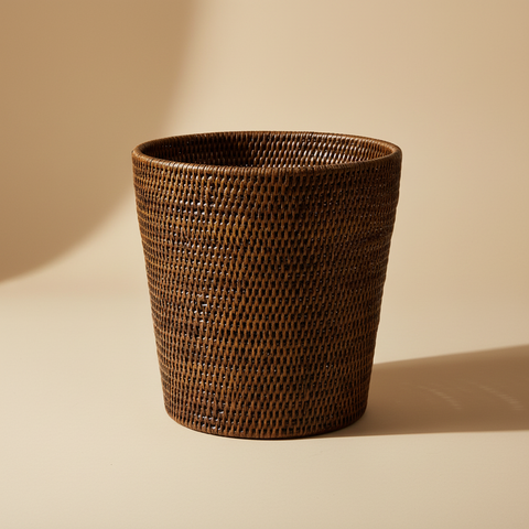 Cestino gettacarte in rattan intrecciato su sfondo beige neutro