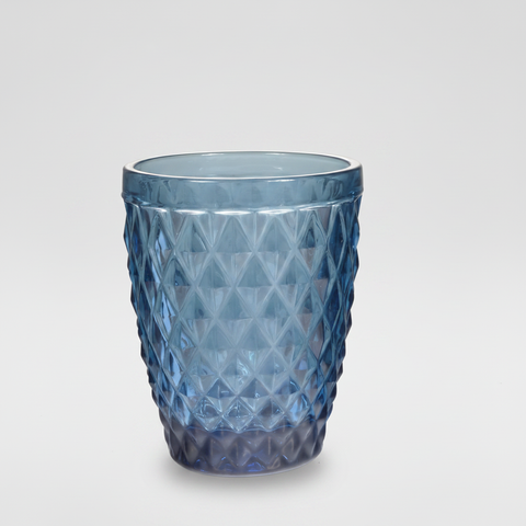 Bicchiere blu diamond-cut su sfondo grigio con ombra