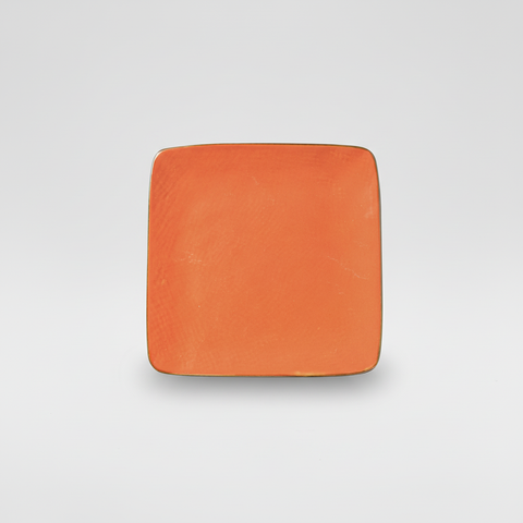 Piatto arancione quadrato su sfondo grigio con ombra