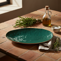 Piatto ovale verde ambientato in cucina mediterranea