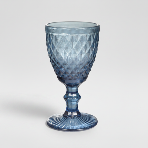 Calice in vetro blu su sfondo grigio con ombra