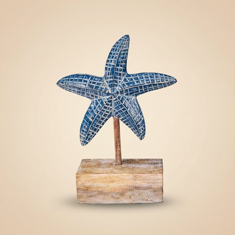 Stella marina in legno blu intagliato su sfondo beige con ombra