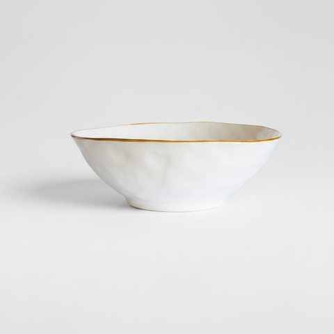 Ciotola ceramica bianca bordo oro su sfondo grigio con ombra