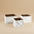 Set di tre fioriere rustiche in legno bianco su sfondo beige caldo