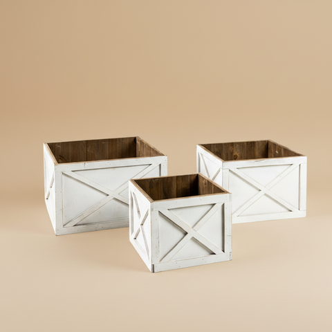 Set di tre fioriere rustiche in legno bianco su sfondo beige caldo