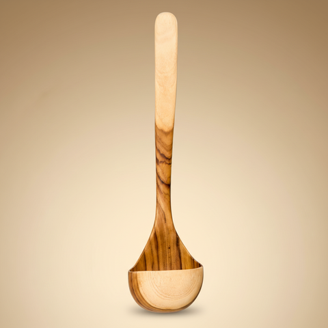 Mestolo in legno d'ulivo su sfondo beige caldo