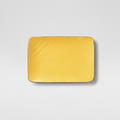 Piatto giallo rettangolare su sfondo grigio chiaro con ombra