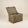 Baule in rattan con lacci in pelle su sfondo beige