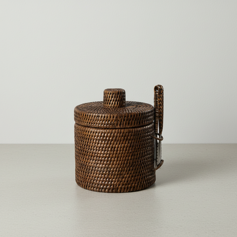 Porta ghiaccio cilindrico in rattan con coperchio e pinza in acciaio inox su sfondo neutro