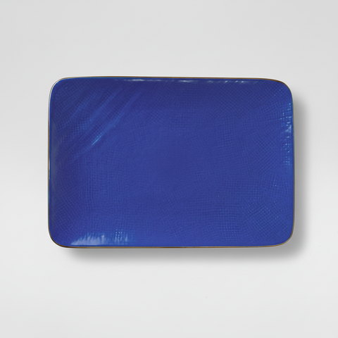 Piatto blu rettangolare su sfondo grigio con ombra