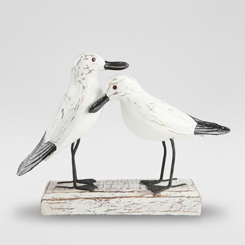 Gabbiani in legno su sfondo grigio con ombra