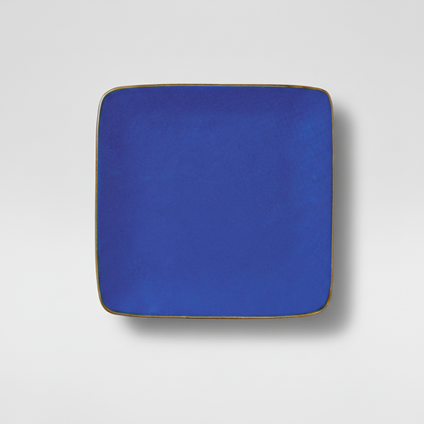 Piatto blu cobalto quadrato su sfondo grigio con ombra