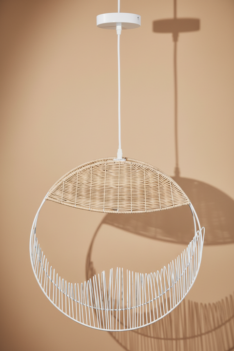 Lampada rattan e metallo bianco su sfondo caldo con ombre