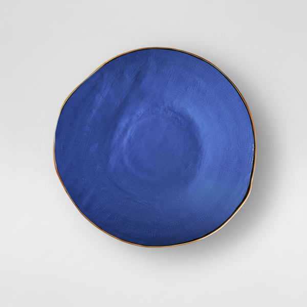 Piatto blu su sfondo grigio con ombra