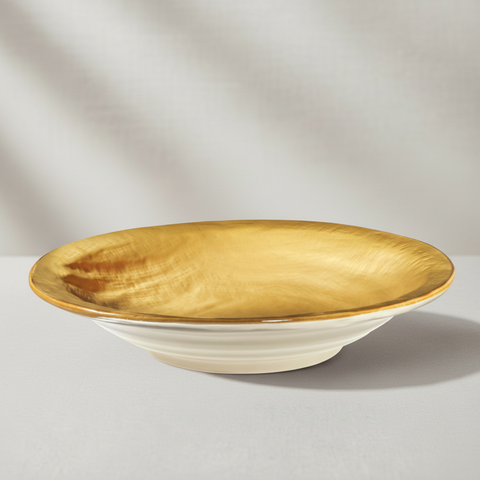 Piatto ceramica bianco con interno oro su sfondo grigio