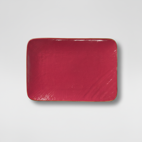 Piatto rosso su sfondo grigio