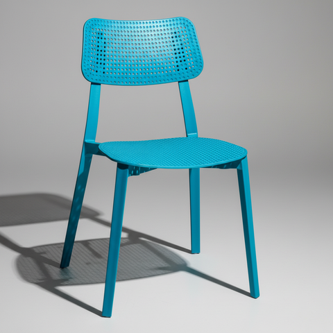 Sedia plastica turchese traforata su sfondo grigio