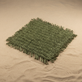 Sottopiatto in rafia verde su sfondo beige