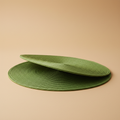 Sottopiatto verde Placemate su sfondo neutro