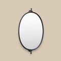 Specchio ovale in metallo nero su sfondo neutro
