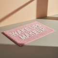 Tappetino rosa Wake Up Makeup su sfondo neutro