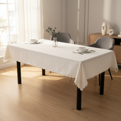Tovaglia bianca con bordo smerlato su tavolo rettangolare