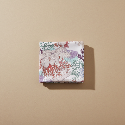 Tovaglia coralli piegata su sfondo neutro